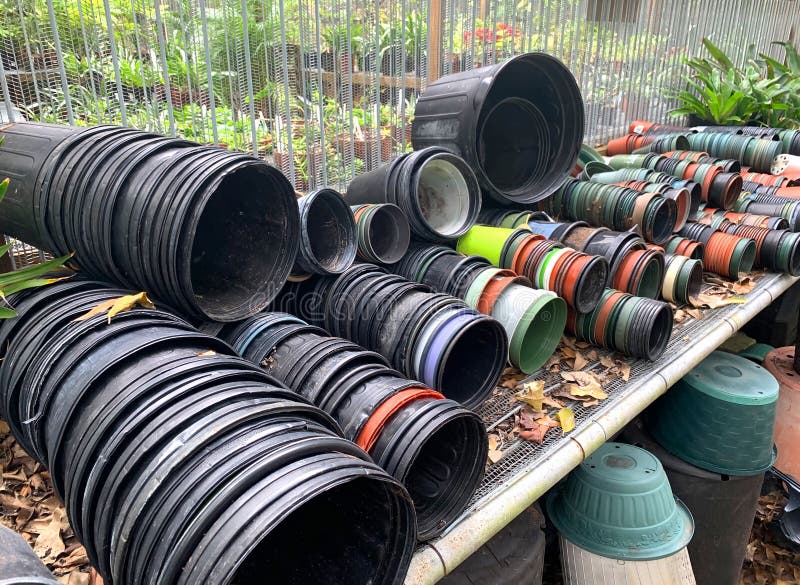 Stacks and stacks of used plastic garden pots laying on their side and ready for potting and planting. Stacks and stacks of used plastic garden pots laying on their side and ready for potting and planting.